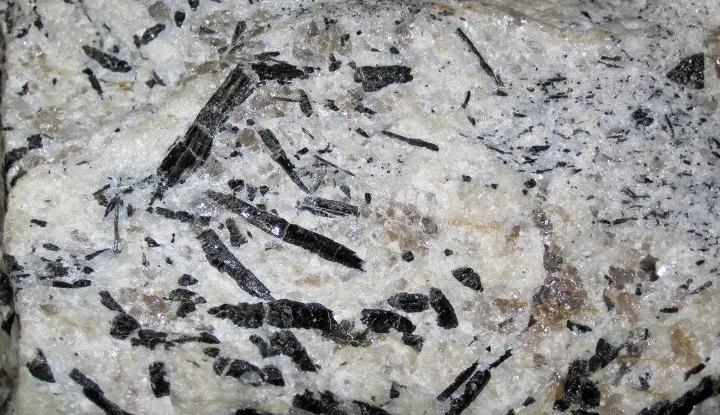 Roca de granito pegmatítico. El mineral negro es turmalina.