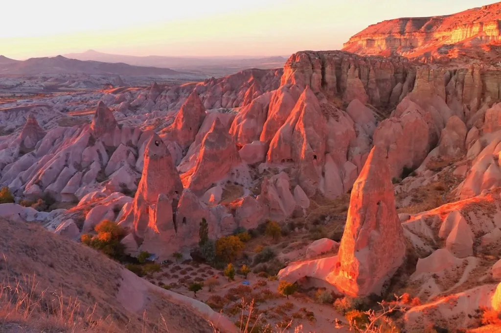 Iron-rich tuff layers in Rose Valley glowing pink at sunset.