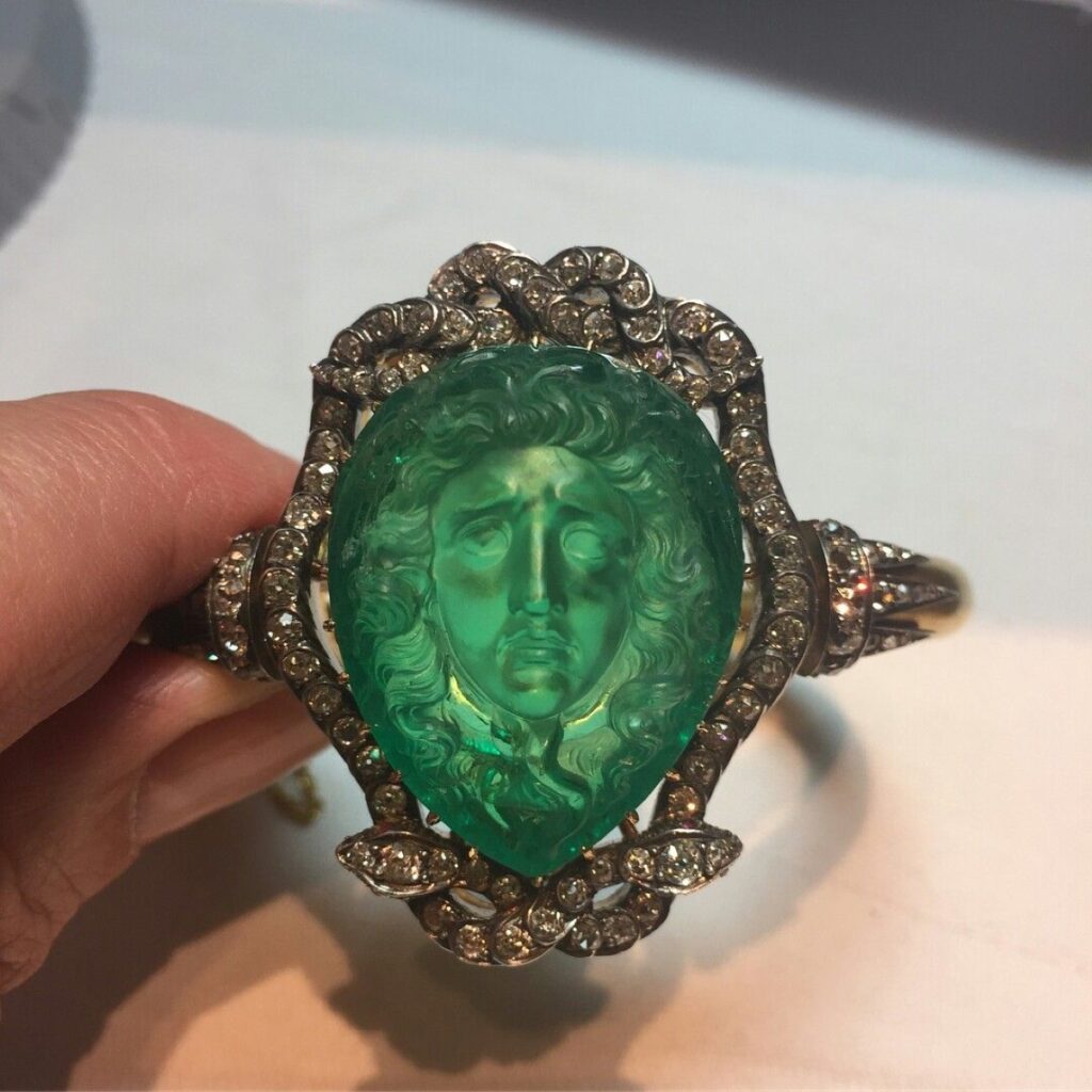 Anillo romano de oro engastado con una gema de amatista grabada con motivos clásicos.