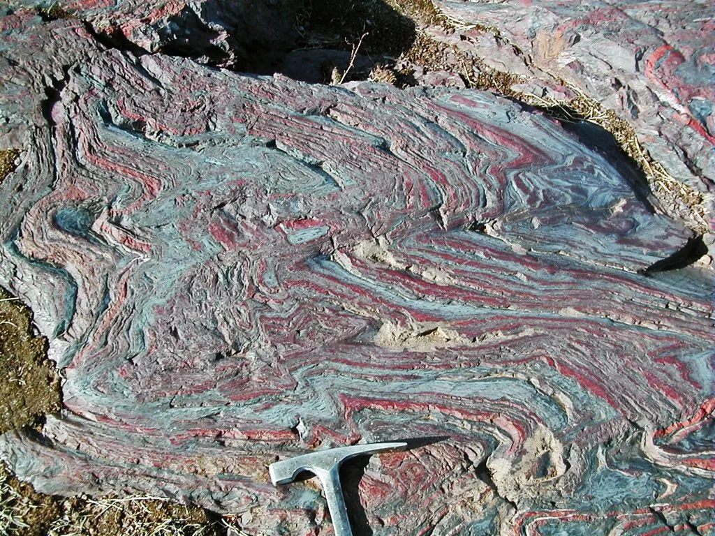 An ancient banded iron formation with alternating iron-rich and silica-rich layers, preserving evidence of Earth's early ocean chemistry.